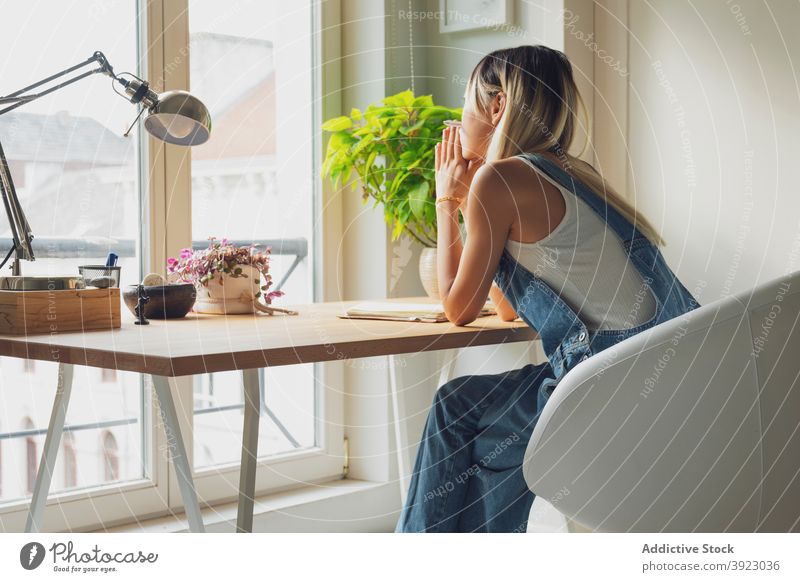 Thoughtful woman sitting at table at home thoughtful pensive contemplate lean on hand ponder think calm female lonely imagination melancholy mood posture