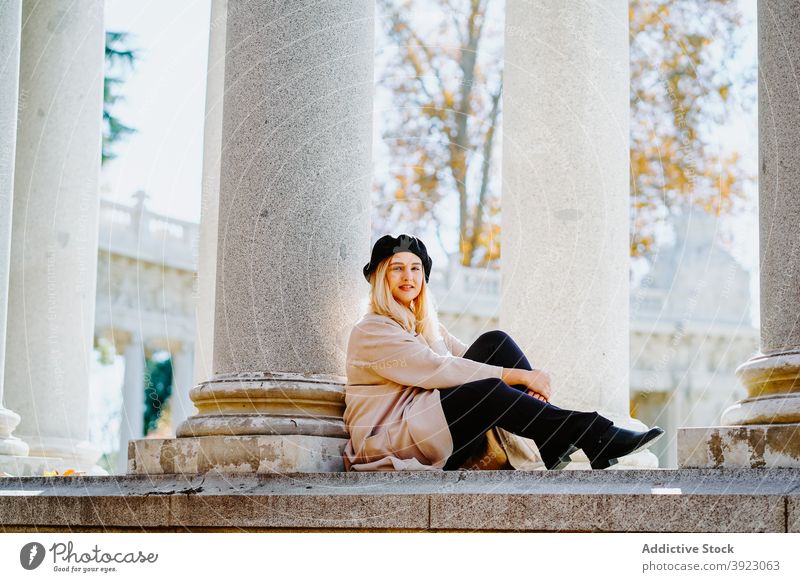 Charming woman in autumn outfit in park charming stroll sunny fall smile enjoy weekend female stone column beret coat style happy cheerful casual outerwear lady