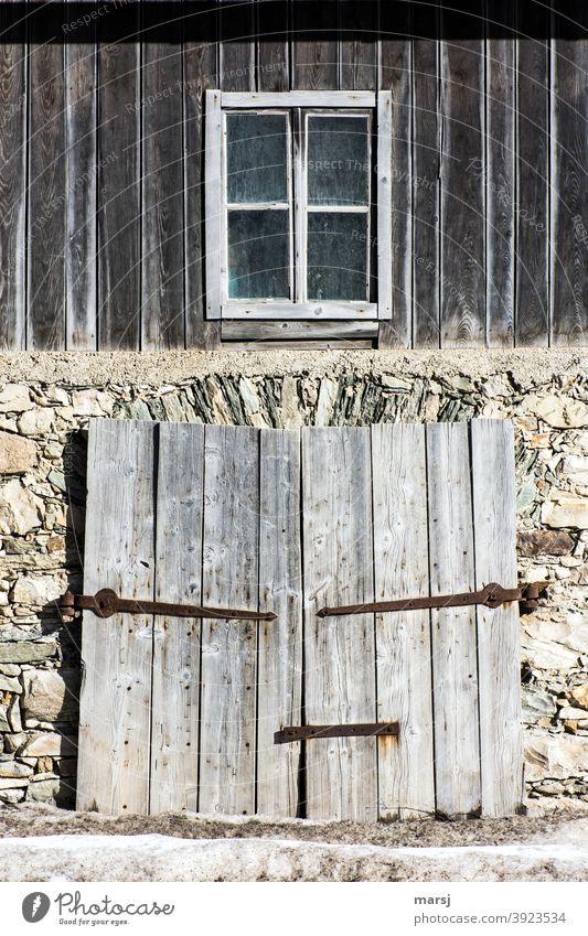 Contemporary history | Everything used to be better. Facade of an old barn, with a two-winged wooden gate and a window in the upper area. Window Wooden gate