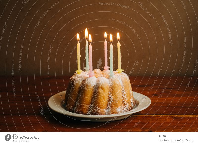 Birthday cake with burning candles on a plate birthday candles birthday cake Cake Happy Birthday Birthday celebration guglhupf Feasts & Celebrations