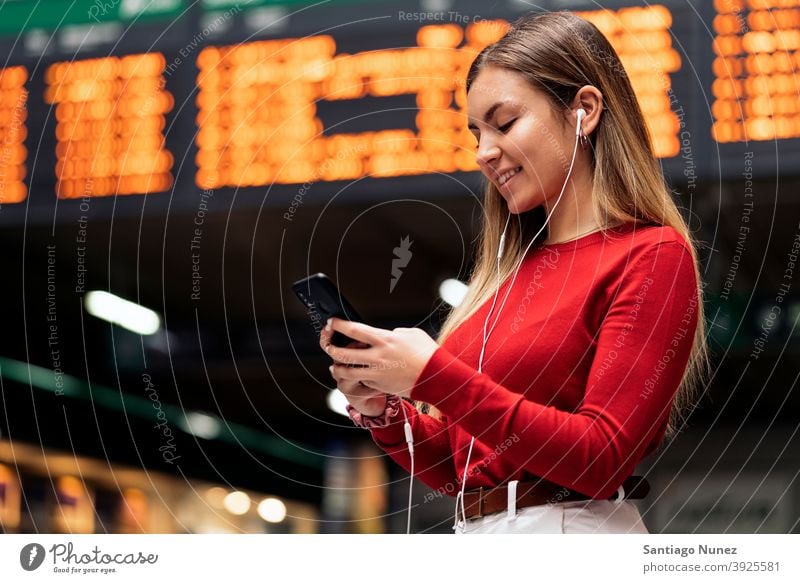Girl in Train Station station train station side view looking at phone headphones girl portrait young 20s blonde pretty using phone cellphone caucasian standing