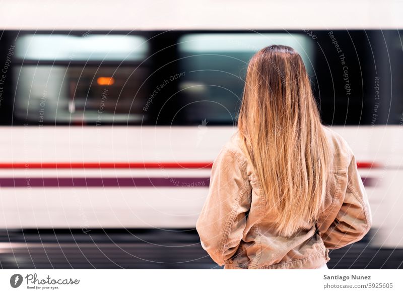 Blonde Girl Waiting for her Train back view train faceless unrecognized motion anonymous blonde standing woman female girl young person background transport