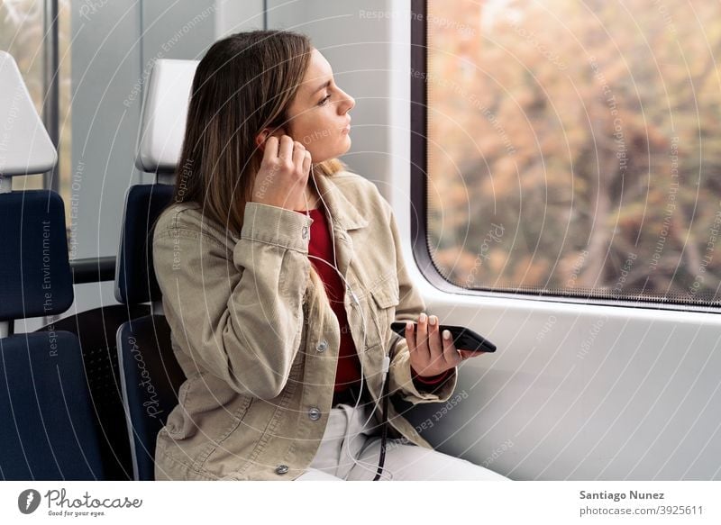 Blonde Girl in Train train traveling headphones girl portrait young 20s front view blonde pretty using phone cellphone caucasian looking standing woman female