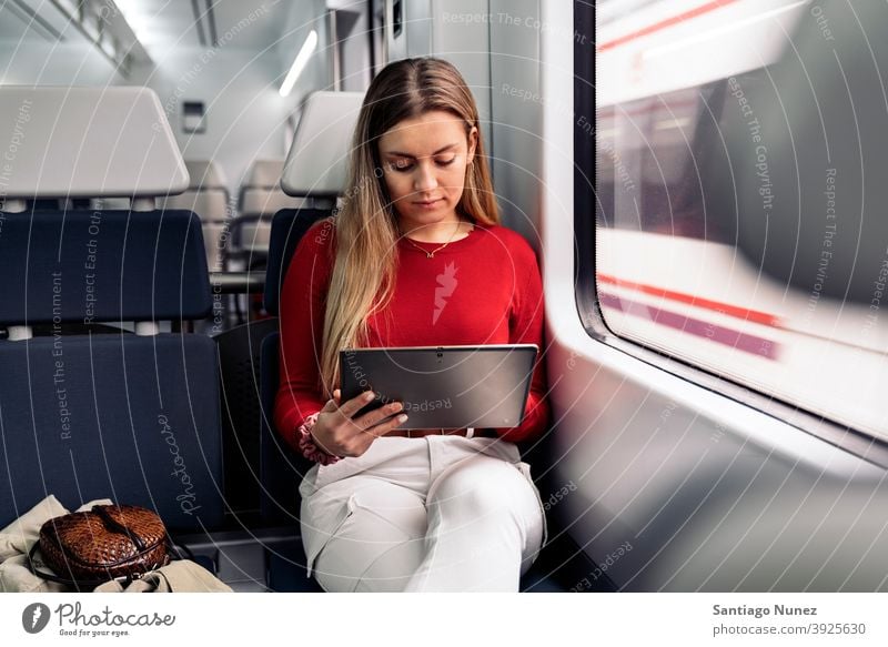 Blonde Girl in Train tablet train traveling girl portrait young 20s front view blonde pretty using tablet caucasian looking standing woman female smartphone