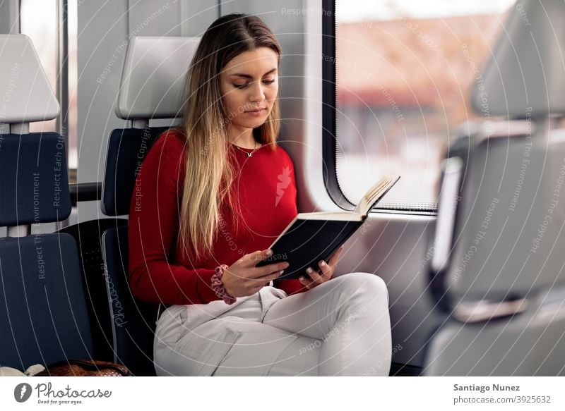 Girl Reading Book in Train book reading focused train traveling girl portrait young 20s front view blonde pretty caucasian looking woman female traveler