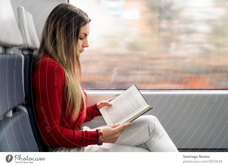 Girl Reading Book in Train side view book reading focused train traveling girl portrait young 20s blonde pretty caucasian looking woman female traveler