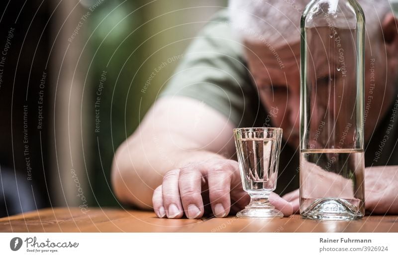 A man stares at his full shot glass, next to it is a bottle of liquor Alcoholic drinks Alcoholics vodka Glass Bottle Man Drinking Beverage Alcoholism