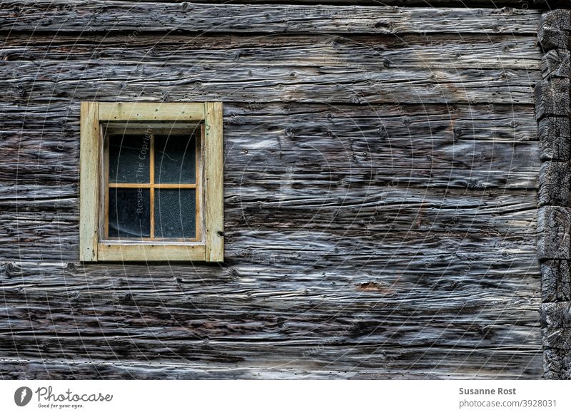 Detailed view of a wooden facade made of thick wooden beams and with a small muntin window Window Facade Wooden window Wooden facade Old Wall (building) Hut