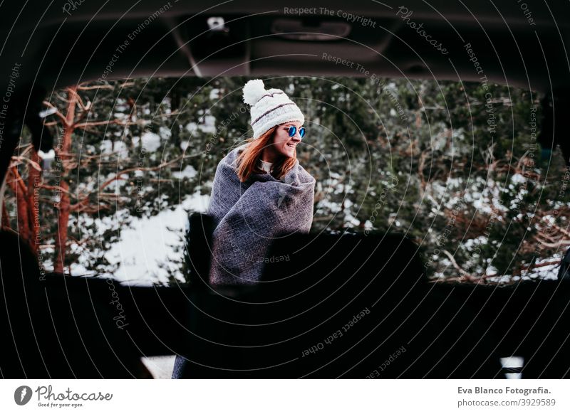 back view from inside a car of young woman outdoors wearing stylish hat. Winter season. snowy mountain background winter enjoy nature leisure green weather