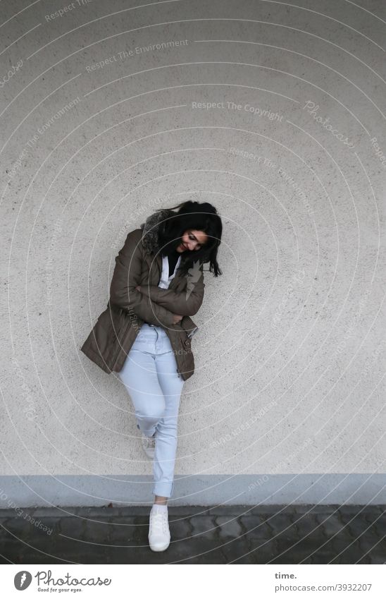 Woman, leaning against a wall Wall (building) Stand Meditative Ajar Jacket jeans Black-haired Long-haired sneakers Wall (barrier) Smiling fortunate
