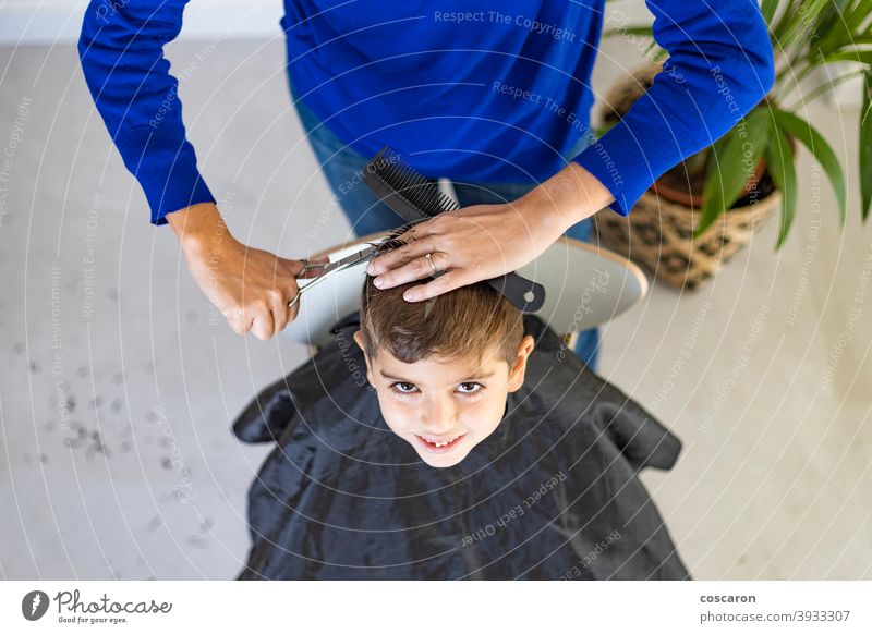 Funny boy getting haircut at home with scissors adorable barber barbershop beauty caucasian child childhood close comb cute equipment face fashion hairdresser