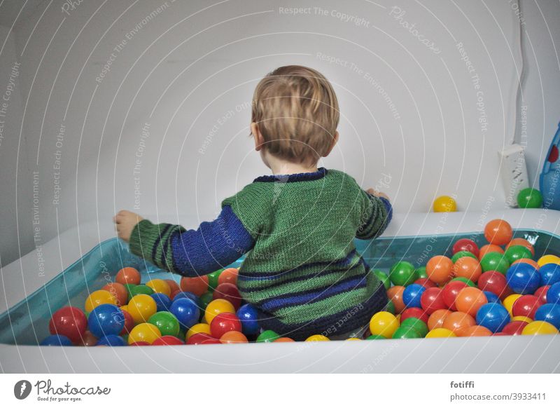 Child in ball pool Playing Toys Ball richness submerged variegated Toddler hollowed Round Infancy Joy Human being Happy Action Rear view childcare