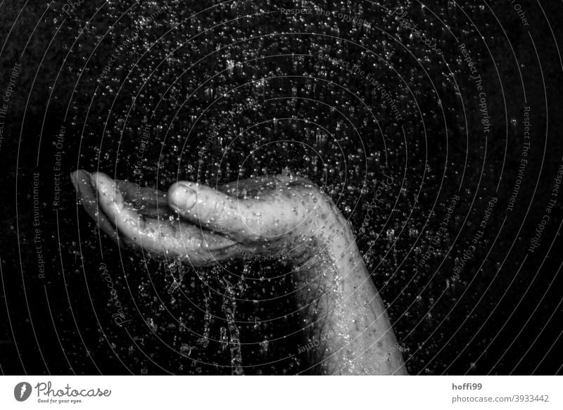 Close-up of a raised hand surrounded by drops of water Hand raised hands Parts of body raindrops Frustration tropics Drops of water powerless uplifted hand