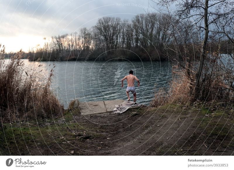 young man jumps into the lake for a swim in winter Ice Swimming Young man masculine Masculine Man Rear view Sportiness Athletic 18 - 30 years cold season