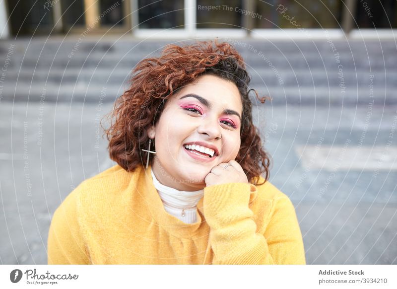 Charming woman sitting on street on sunny day plus size casual style city relax stair charming curly hair appearance female chubby cheerful smile glad enjoy