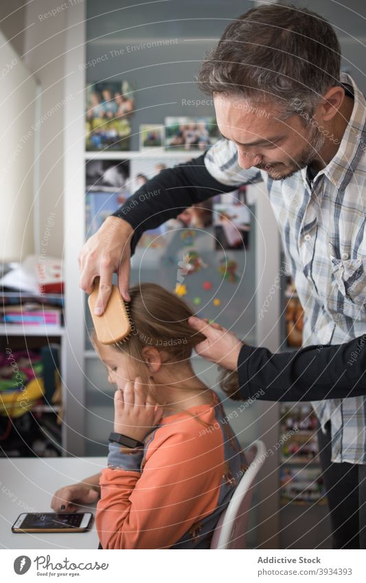 Dad brushing hair of daughter father comb care love kid child dad daily together parent relationship careful lifestyle bonding parenthood fatherhood long hair