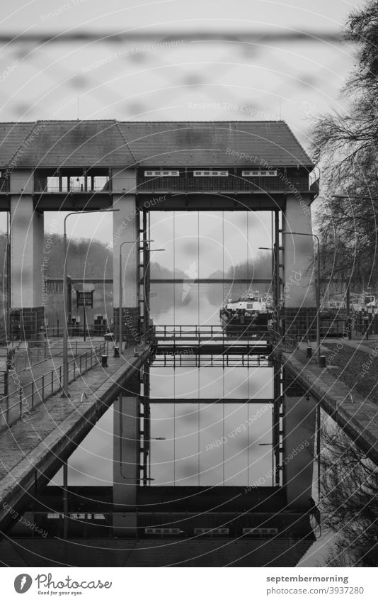 Lock gate with water and ship in the background Autumn Haze Lock system black-white Deserted Exterior shot Barge
