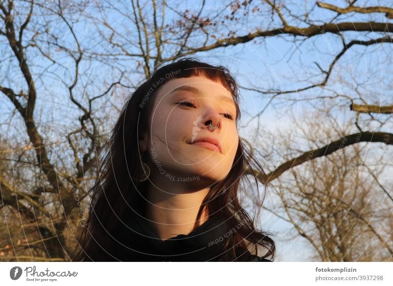 Portrait of young smiling woman under bare trees Woman Face of a woman portrait smilingly Long-haired Identity feminine Looking look optimistic Girl