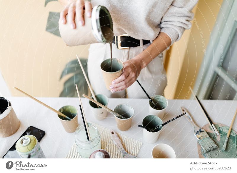 Woman mixing colors for creating painting on wall artist painter woman home pigment pour female monstera leaf mask protect cup talent create hobby craft prepare