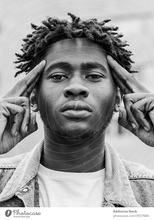 Black man with dreadlocks looking at camera hipster afro portrait serious modern young style confident male ethnic african american black trendy millennial