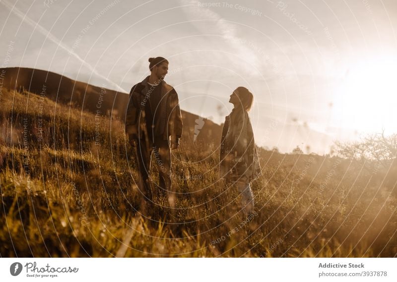 Couple standing together in field at sunset couple love retro outfit style vintage sundown affection evening happy relationship young romantic tender amorous