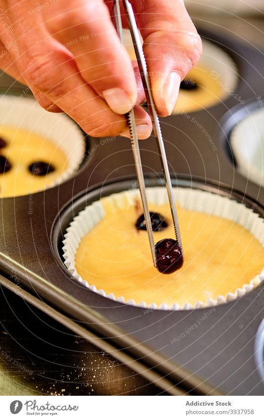 Pastry chef making muffins with berries pastry bakery confectionery dough berry add prepare kitchen professional culinary tong sweet dessert cook food cuisine