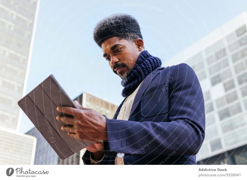 Black male entrepreneur using tablet in city freelance man browsing work project remote business ethnic black african american gadget device connection online