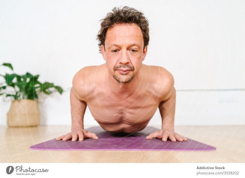 Man practicing yoga in studio man practice child pose stretch flexible harmony relax asana peaceful mindfulness naked torso zen tranquil stress relief male calm