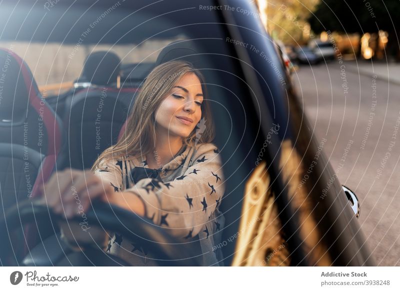 Positive young woman driving car drive steering wheel automobile windshield road smile trip vehicle female transport driver road trip travel lifestyle modern