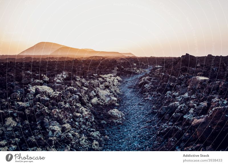 Spectacular landscape of volcanoes under sundown sky volcanic terrain nature path trail sunset mountain crater picturesque idyllic cloudless lanzarote canary