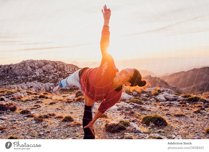Crop anonymous person supporting concentrated woman performing Natarajasana yoga pose in mountains natarajasana lord of the dance together balance wellness