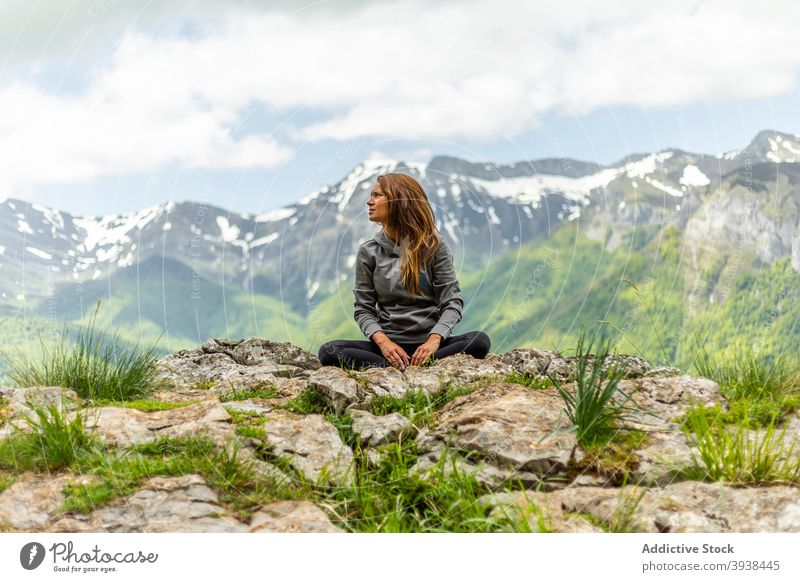 Young lady recreating in Padmasana pose in picturesque mountainous valley woman relax lotus pose padmasana traveler admire nature recreation yoga vacation
