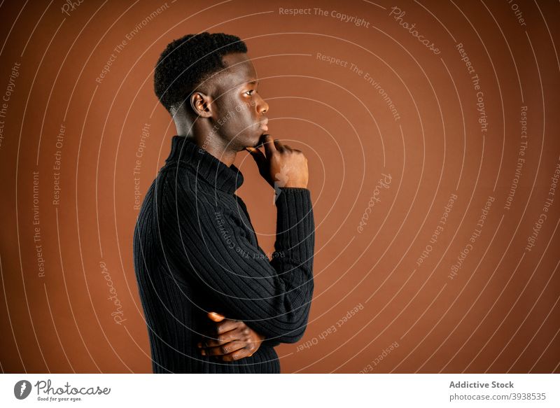 Thoughtful black man in casual outfit in studio thoughtful rubbing chin pensive serious think contemplate style male ethnic african american touch chin ponder