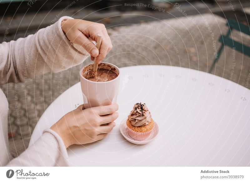 Anonymous woman having coffee break with dessert in cafe confectionery cupcake candy eat sweet cafeteria terrace food female tasty delicious yummy treat