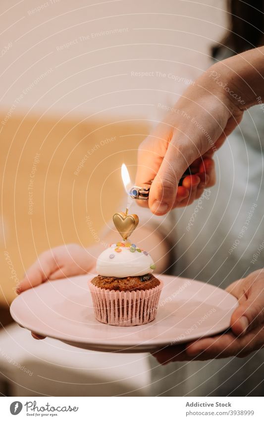 Birthday cupcake with burning candle birthday festive celebrate sweet dessert event food occasion hand light flame holiday yummy treat sprinkle cream baked