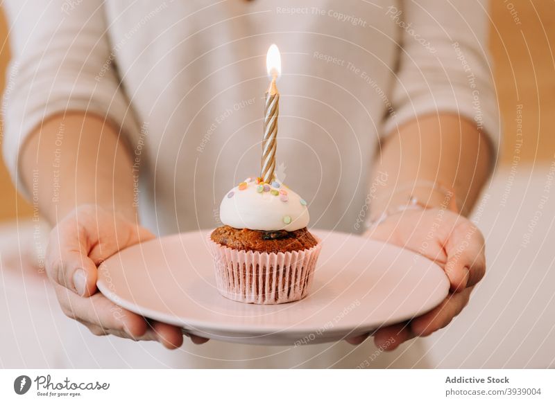 Woman serving birthday cupcake with candle festive celebrate sweet dessert event food woman occasion burn flame holiday yummy treat cream baked decor decoration