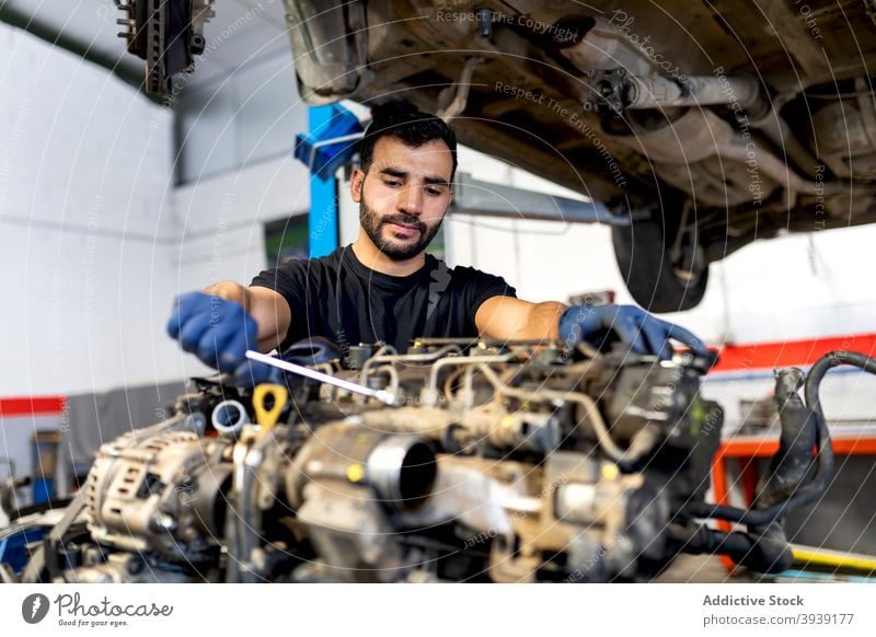 Male mechanic fixing car in workshop man engine service examine wrench spanner motor male technician professional automobile job diagnostic transport