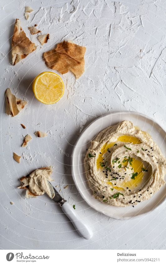 Top down view of a plate of hummus with lebanese flat bread and lemon on a white background appetizer arab arabic arabic food chickpea cooking cuisine delicious