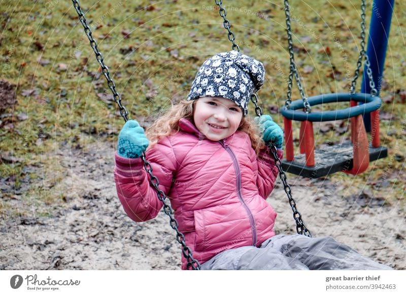 Girl on the swing Winter Playground To swing Swing Playing Child Infancy cheerful child Joy red jacket Laughter laughing child 3 - 8 years Nursery school child