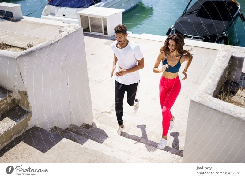 Athletic couple training hard by running up stairs together outdoors. fitness step workout sport woman girl female activity young leisure jogger caucasian