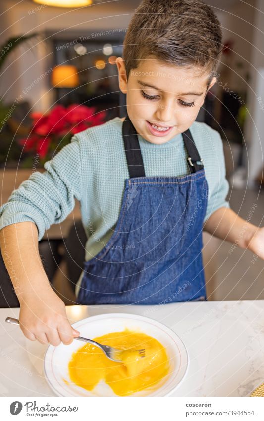 Little boy beating a egg in the kitchen activities baking biscuits bowl cake chef child childhood children cook cookies cooking croquettes cute dessert family