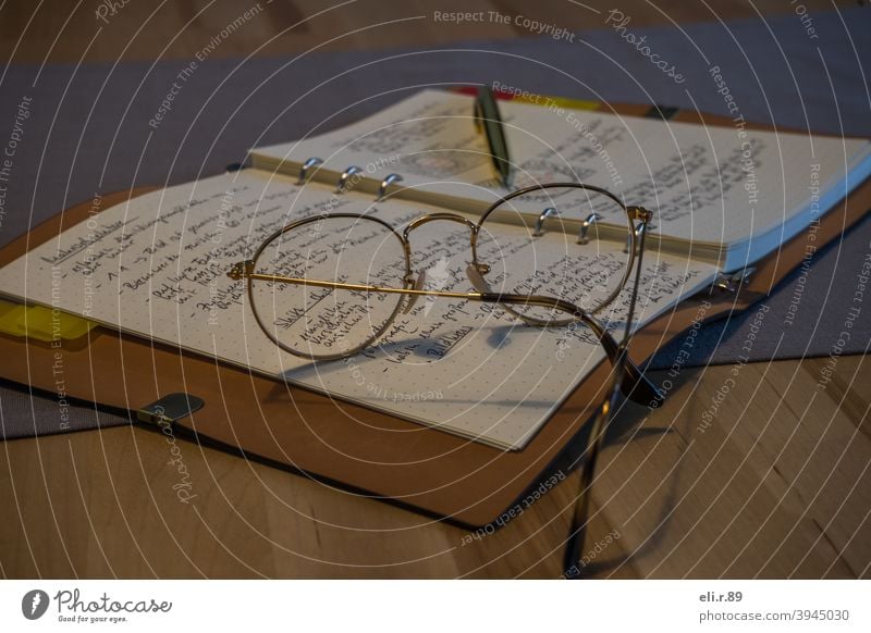 Glasses on a notebook Eyeglasses Book Letters (alphabet) Reading Know School Education Study Paper at home stay at home Colour photo Interior shot