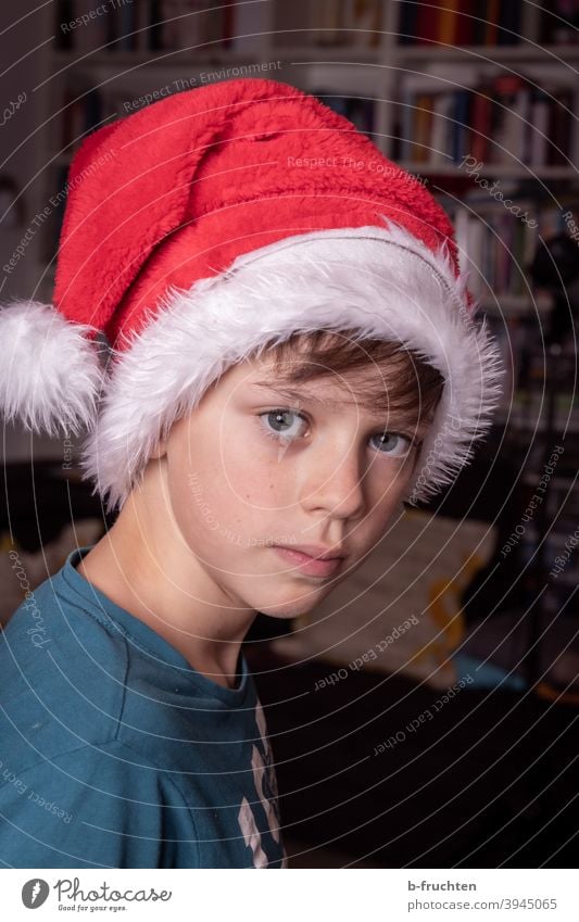 Child with Christmas hat Joy Cap Red Christmas & Advent Feasts & Celebrations Santa Claus hat Colour photo Interior shot Infancy room Boy (child) Skeptical