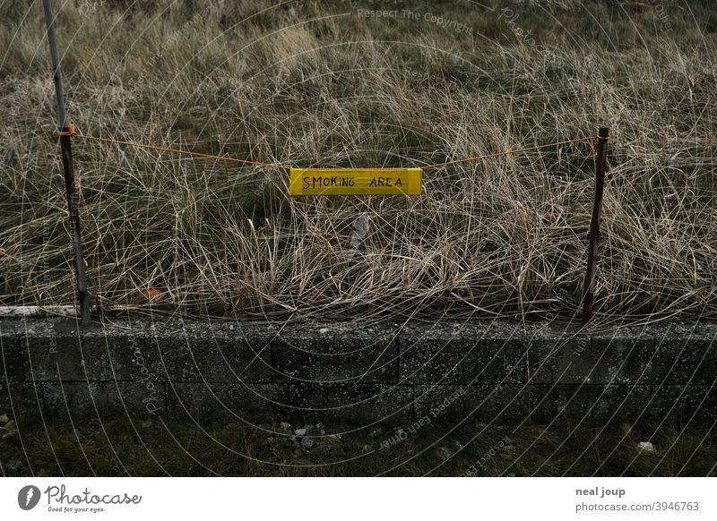 Handwritten sign "Smoking Area" at the roadside Clue smoking Signage Exterior shot Characters Handwriting Addiction range Places Gloomy Grass Wall (barrier)