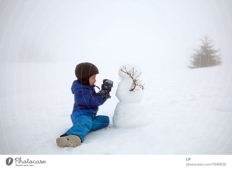 child making a snowman Snow Snowman Portrait photograph Exterior shot Delightful emotional seasonal Snowflake holiday Action kid Make Clothing Weather Nature