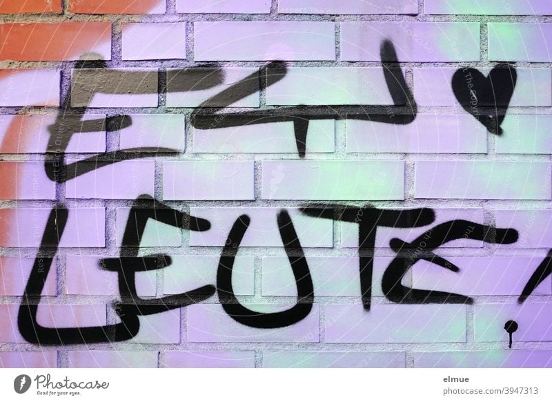 A small heart and "EY LEUTE !" are sprayed in black on a green-purple brick wall / graffito / youth language / lifestyle Hey guys Heart Graffito Graffiti Daub