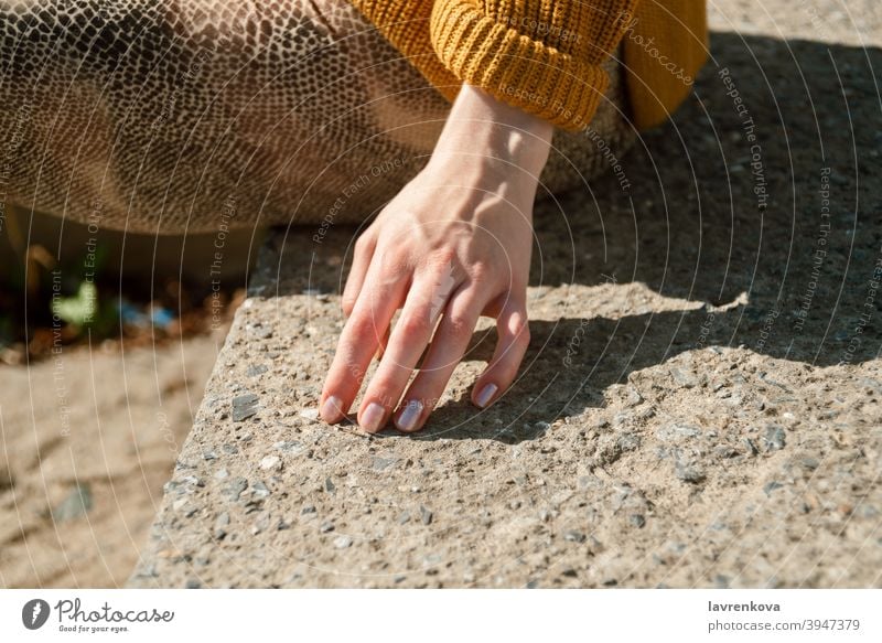 Closeup of female hand touching stone stairs outdoors lifestyle girl nails accessories closeup detail stones arm finger woman spring season summer details