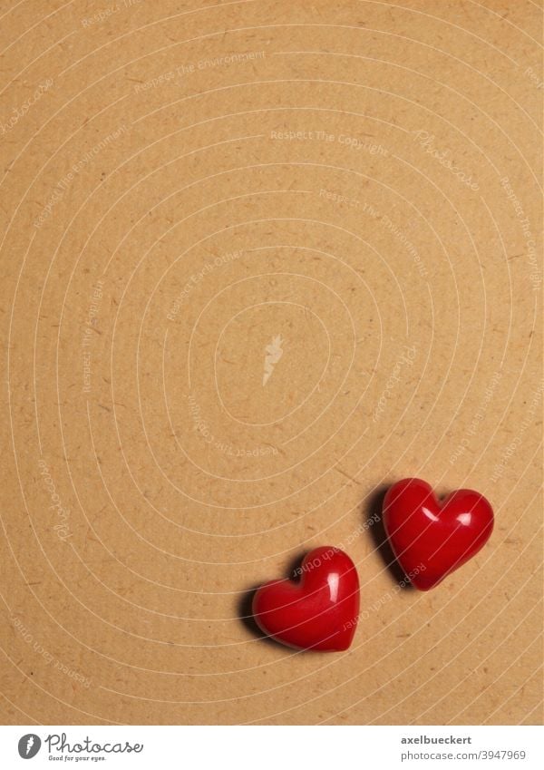two red ceramic hearts on love letter paper background - a Royalty Free  Stock Photo from Photocase