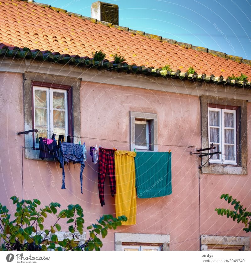 Old Mediterranean style house with clothesline full of laundry. Facade with roof and windows House (Residential Structure) Laundry Window Roof variegated Sky