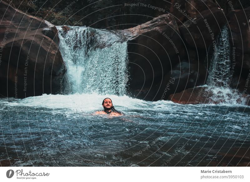 A man enjoying a swim in the waterfall swimming in a waterfall back to nature outdoor pursuit one man only active lifestyle tourist adventure wanderlust